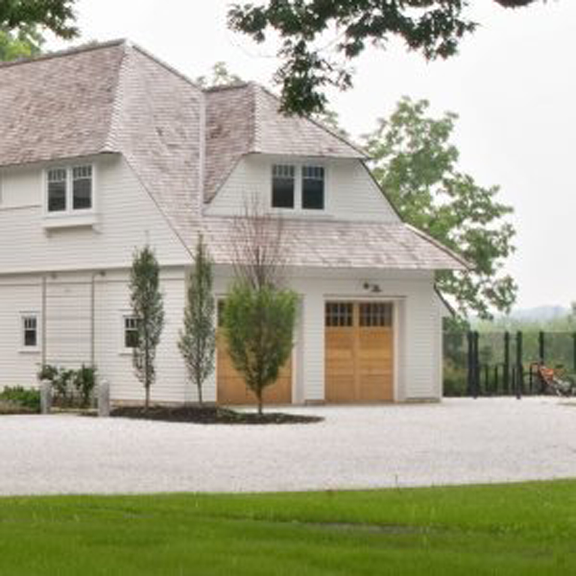A transitional style home designed by Nautilus Architects in Upstate New York with a two-car wood panel garage